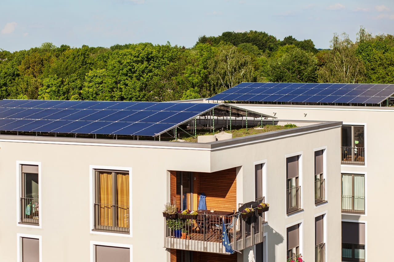 Paneles solares montados en terraza de edificio para autoconsumo compartido
